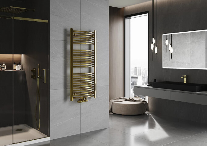 Radiateur doré avec tête thermostatique dans la salle de bain